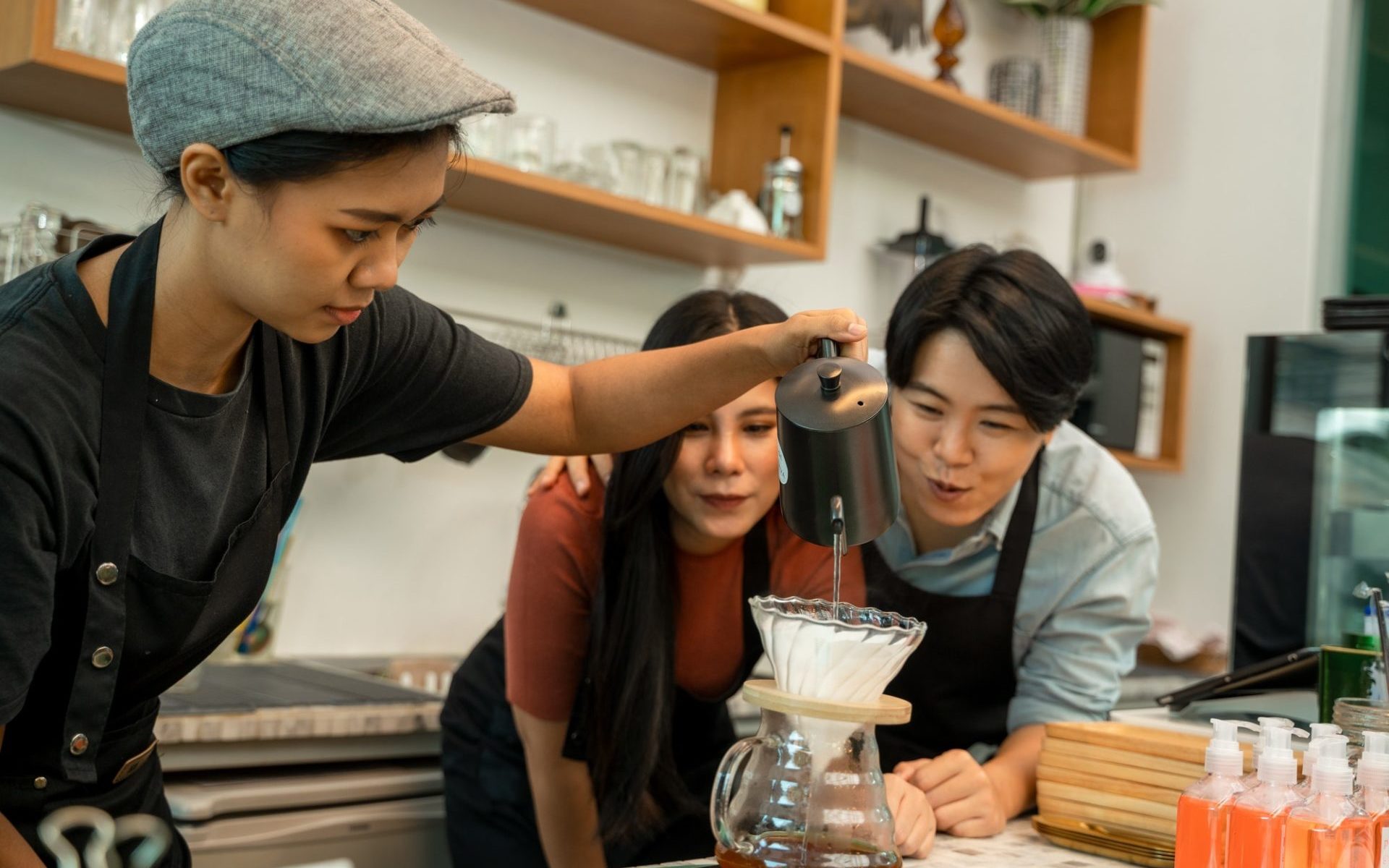 barista-pouring-boiling-water-from-kettle-to-drip-coffee-maker-at-the-bar-of-the-modern-cafe--e1651630662286.jpg